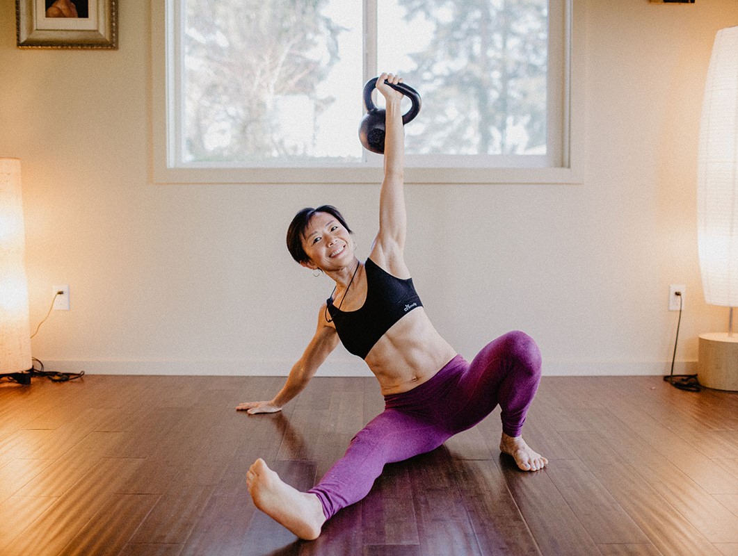 A woman doing a turkish get up with a kettlebell